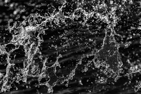 water drops in the air on a dark bokeh backgroundの写真素材