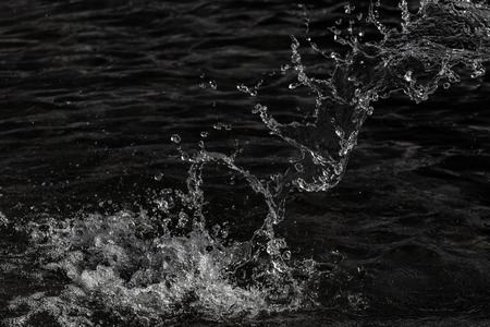water drops in the air on a dark bokeh backgroundの写真素材