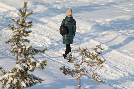 winter, a man walks through the snow in the forestの写真素材