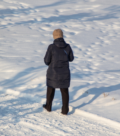 winter, a man walks through the snow in the forestの写真素材