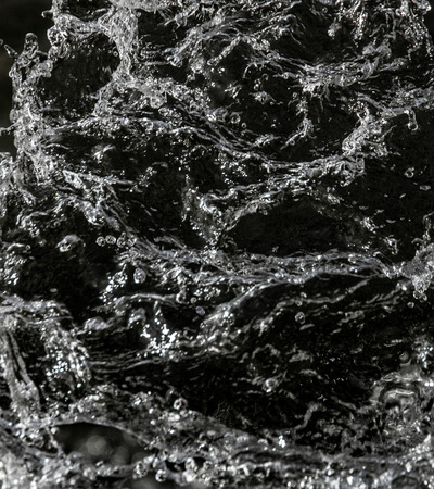 water drops in the air on a dark bokeh background