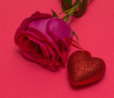 Flower rose and red heart on a pink background. Red heart on a pink background. St. Valentine's Day Beautiful background from hearts. Concept of love and romance.の写真素材