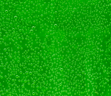 round air droplets in water on a green background