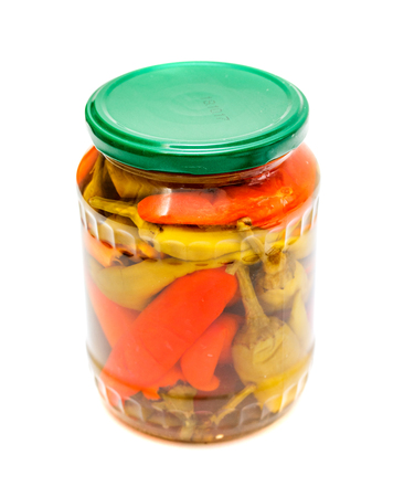 Glass jar with pickled peppers on a white background.の写真素材