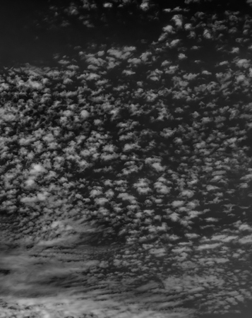 White clouds on a dark sky, monochrome.の写真素材
