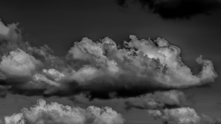 White clouds on a dark sky, monochrome.