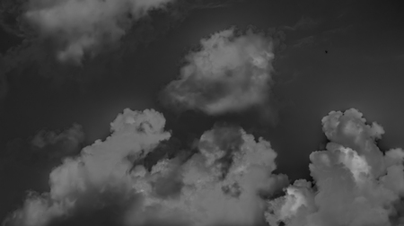 White clouds on a dark sky, monochrome.