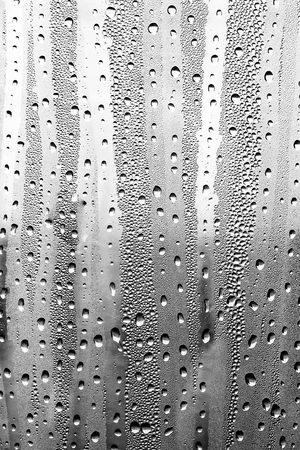 Raindrops on the glass, black-white background, fashion glass texture.の写真素材