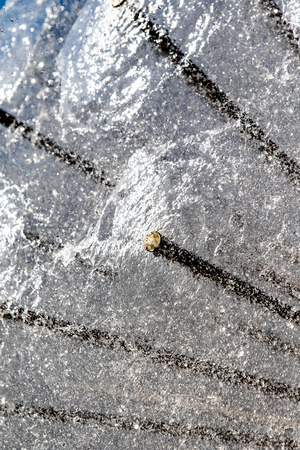 Water splashes from a metal circle fountain.の写真素材