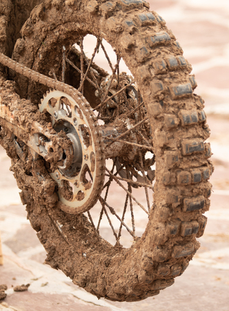Motorcycle wheel in mud clay closeup on the street.の写真素材