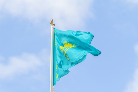 Flag of the Republic of Kazakhstan against the blue sky, wind.の写真素材