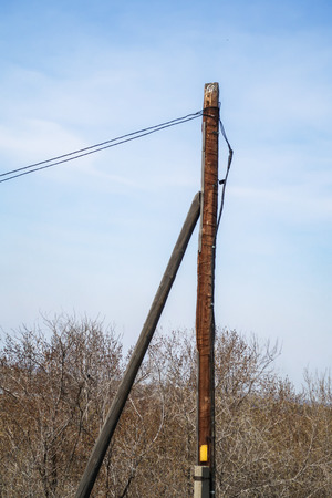 A pillar with wires against a blue sky.の写真素材