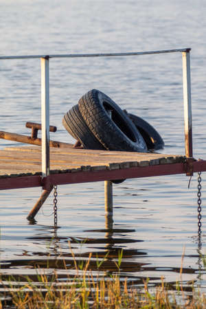 Petropavlovsk, Kazakhstan - September 14, 2019: Old tires in the water on the lake. Environmental pollution.の写真素材