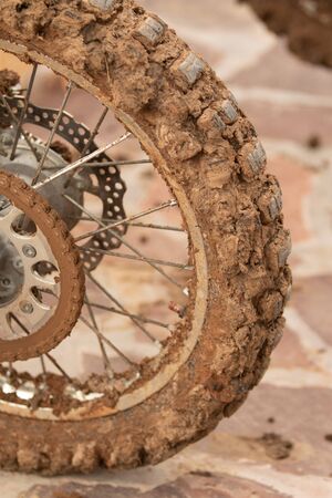Motorcycle wheel in mud clay closeup on the street.の写真素材