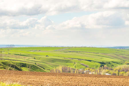 Landscape green field hills sky with clouds
