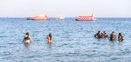 Sharm el-Sheikh, Egypt - November 11, 2017: Naama Bay sea beach in Sharm el-Sheikh, Egypt. People bathe, rest. Boats are sailing in the sea.のeditorial素材
