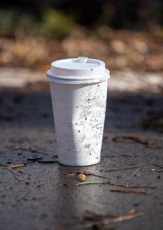 White paper cup on the ground. Garbage in the forest.の写真素材