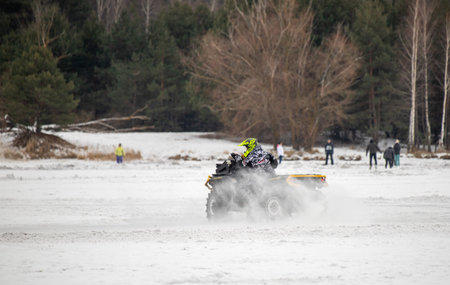 Petropavlovsk, Kazakhstan - 04.02.2023:ATVs on the snowy ice of the lake. In winter, young people ride ATVs on the ice.の写真素材