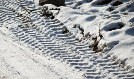 snow covered road with footprintsの写真素材