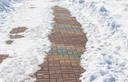 snow covered road with footprintsの写真素材