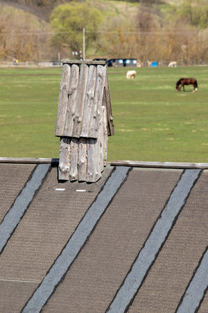 house with a wooden roof in the village against the blue skyの写真素材