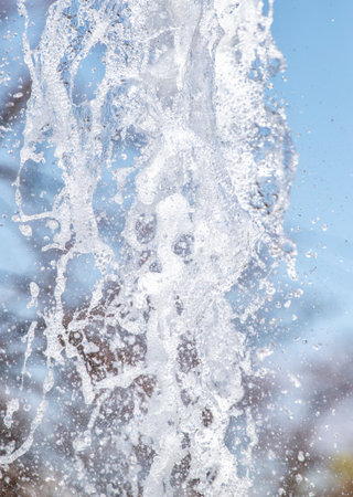 splashing water from a fountain against the blue skyの写真素材