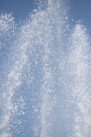 splashing water from a fountain against the blue skyの写真素材