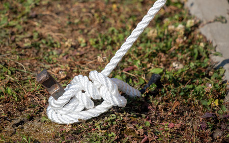 a strong rope tied to a metal post in the groundの写真素材