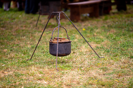 Metal camping pot on a tripod on green grassの写真素材