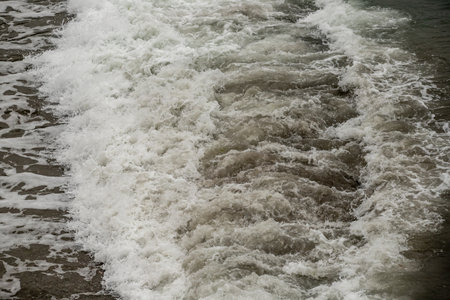 Strong foamy sea wave on the shore.