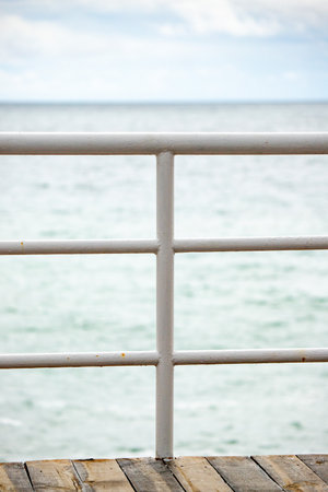 White railing on a pier by the sea. Selective focus.の写真素材