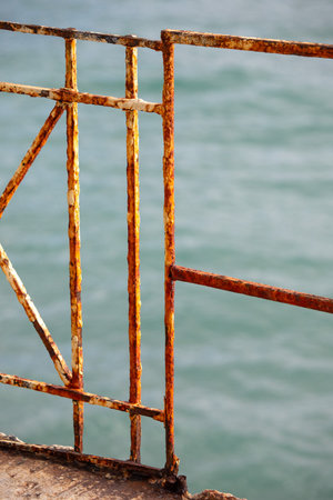 Rusty metal fence on the sea background, closeup of photoの写真素材