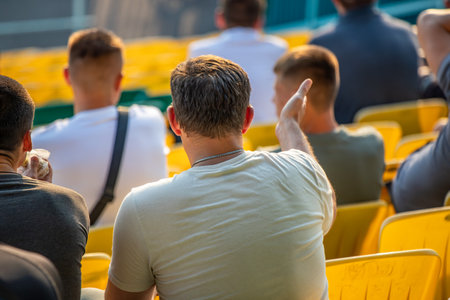 A man in a white shirt is sitting in a yellow chair. He is looking at something in the distanceの写真素材