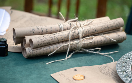 A bunch of old papers are tied together with string. The papers are written on and appear to be from a bygone era. Concept of nostalgia and curiosity about the contents of the papersの写真素材
