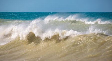 The ocean is rough and the waves are high. The water is a mix of blue and whiteの写真素材