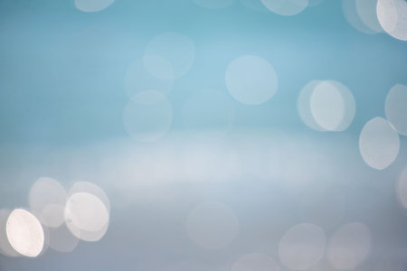 A blue background with white circles. The circles are blurry and overlapping. The image has a dreamy, ethereal quality to itの写真素材