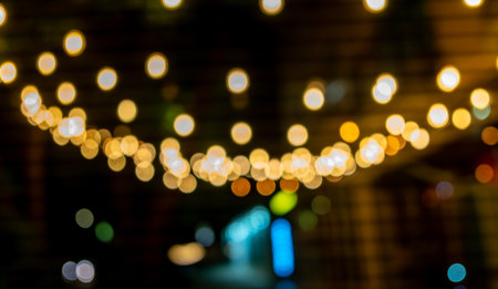 A bunch of lights are hanging from the ceiling, creating a warm and inviting atmosphere. The lights are scattered throughout the room, with some shining brightly and others dimlyの写真素材