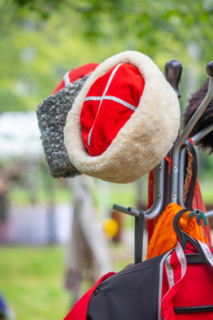 Two hats hanging on a rack, one is red and the other is white.の写真素材