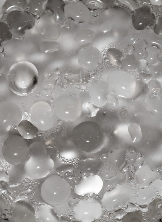 The image is a close up of a bunch of small, clear, round objects. The objects are scattered throughout the image, with some closer to the foreground and others further backの写真素材