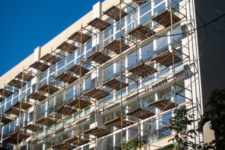 A building under construction with scaffolding on the side. The scaffolding is being used to support the building as it is being builtの写真素材