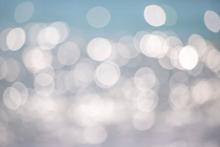 The image is a blurry, hazy view of the ocean with many small, white circles. Scene is calm and peaceful, as the circles seem to be floating on the water's surfaceの写真素材