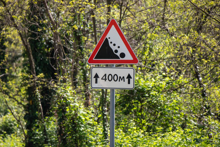 A sign with a black and white triangle and the number 400 on it. The sign is in a forestの写真素材