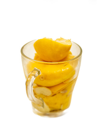 A glass of sliced lemons in a cup. The lemons are cut in halfの写真素材