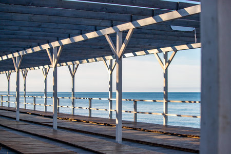 A wooden structure with a view of the ocean. The structure is open and has a lot of sunlight coming inの写真素材