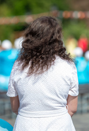 A woman with long hair is wearing a white dress. She is looking at the camera. The image has a calm and peaceful moodの写真素材