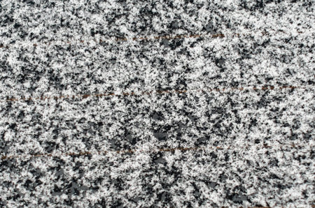 A large rock covered in snow and a black and white pattern. The rock appears to be a mix of gray and...
