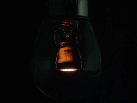 Old dusty light bulb glowing in the dark