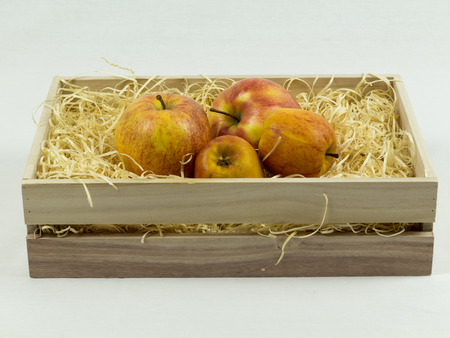 Apples in wooden crate on strawsの写真素材