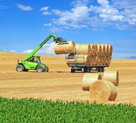 Loading bales of straw on an agricultural trailer