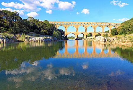 The Pont du Gard reflecting in the Gard in Occitanie, France.の写真素材